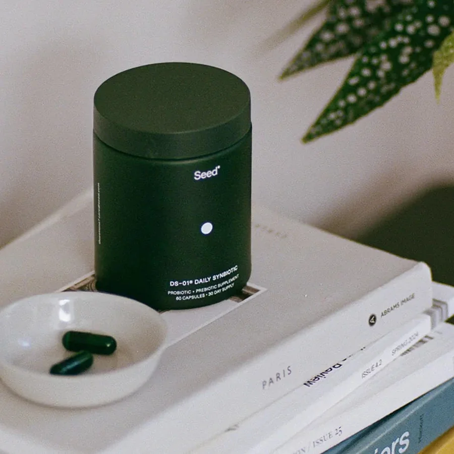 Seed DS-01 Daily Synbiotic jar with two capsules on a small dish